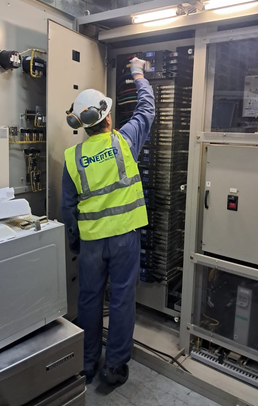 Técnico de ENERTED realizando inspección y mantenimiento preventivo en tablero de subestación eléctrica industrial