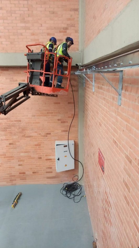 Técnicos de ENERTED realizando mantenimiento eléctrico industrial en altura para Bosch.