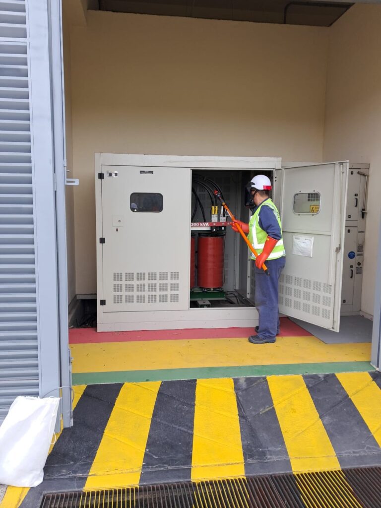 Técnico realizando inspección de equipo eléctrico de respaldo UPS en instalación industrial.