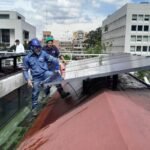 Operario levantando un panel solar durante la instalación