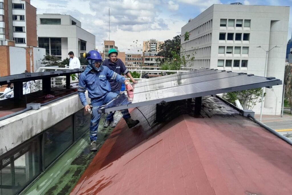 Operarios instalando paneles solares en la cubierta de un edificio