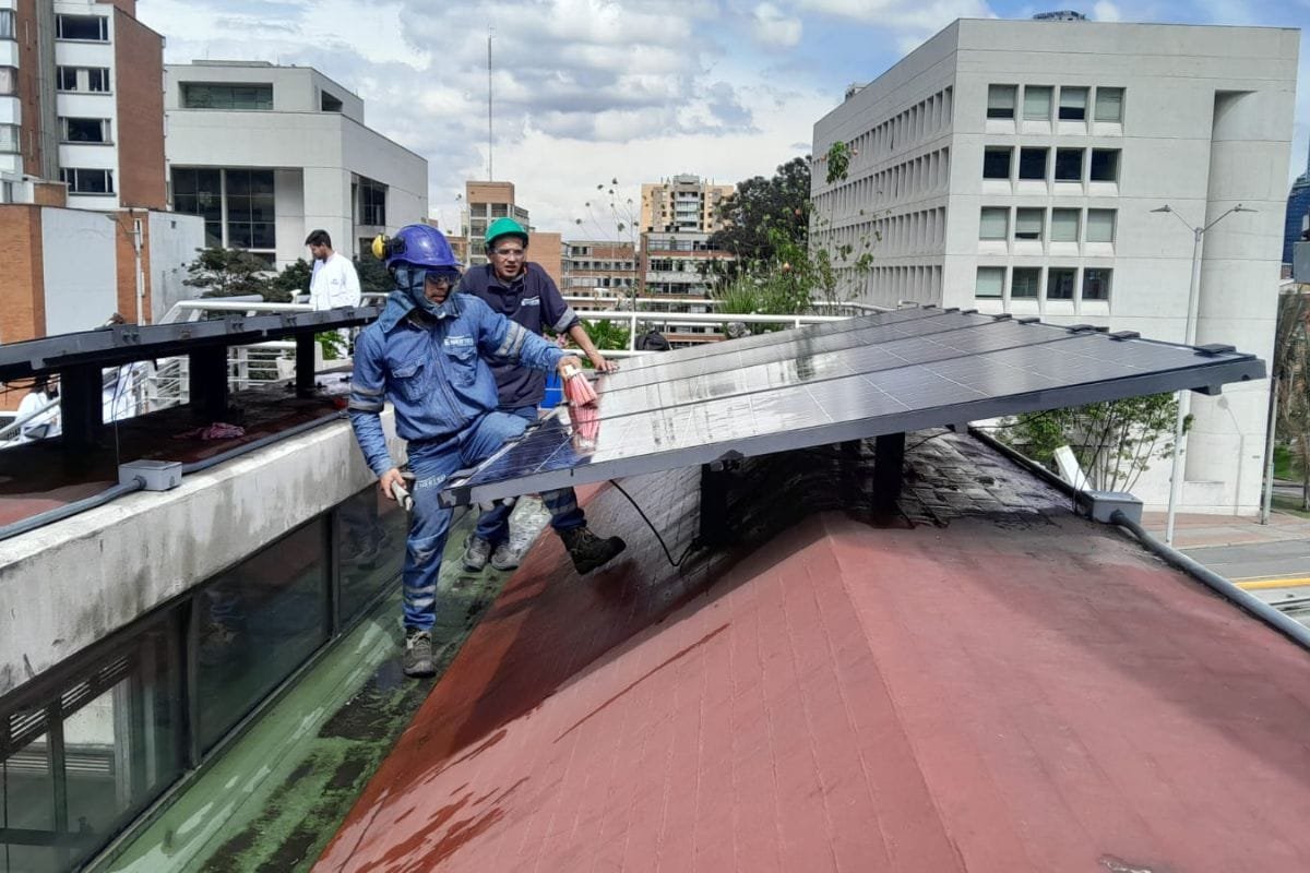 Operario levantando un panel solar durante la instalación