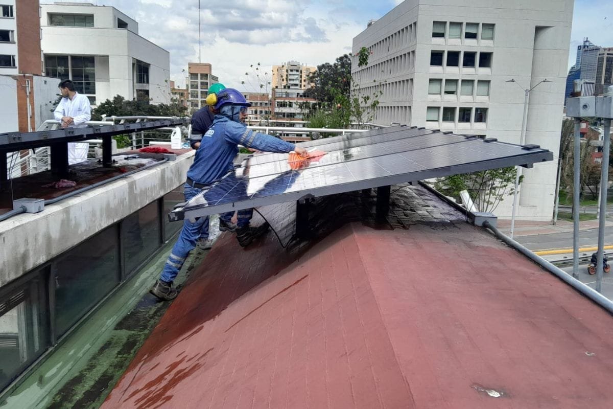 Operario fijando un panel solar sobre una cubierta industrial