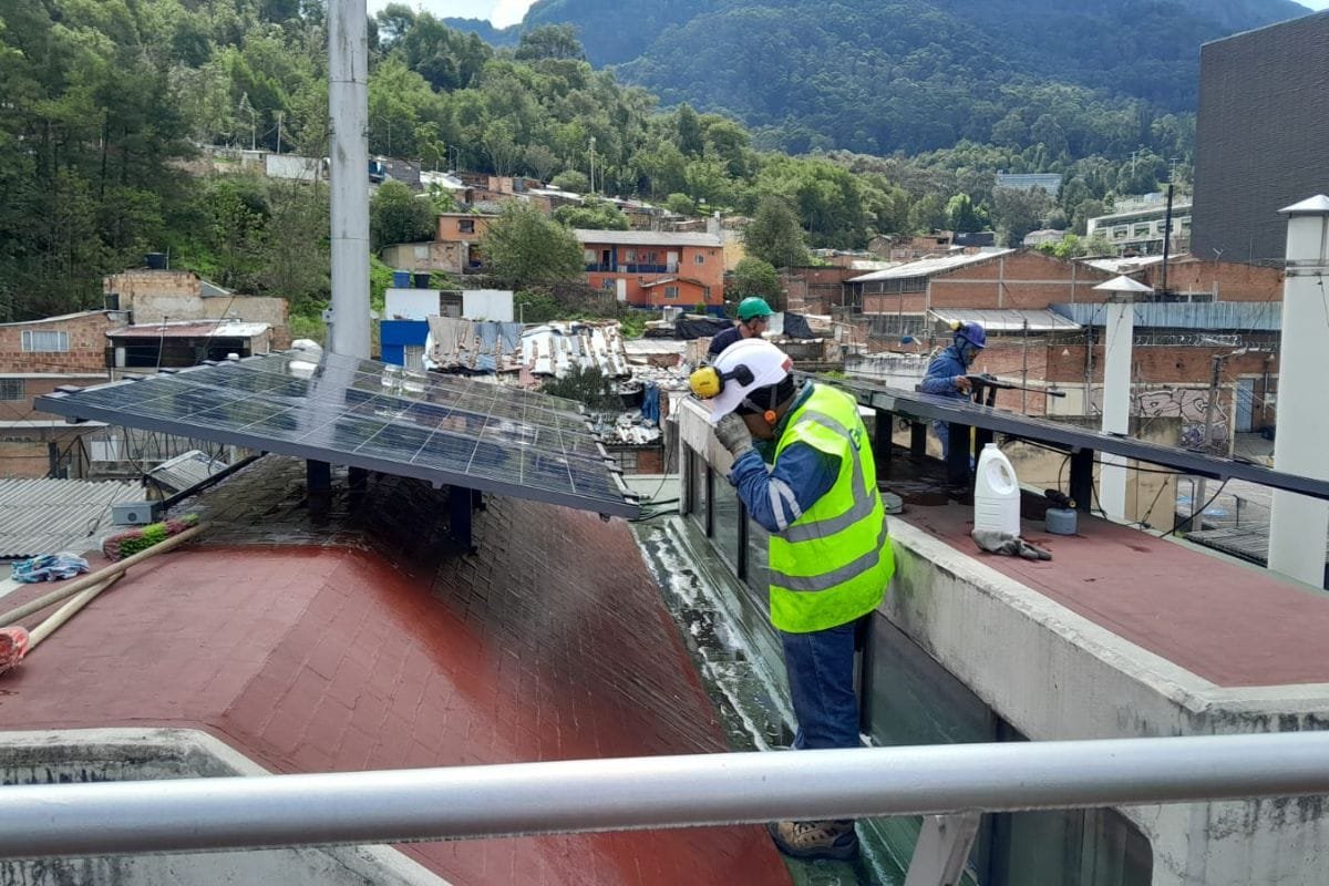Operarios ajustando paneles solares sobre la cubierta de un edificio