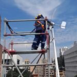 Operario montando estructura metálica en altura sobre andamio