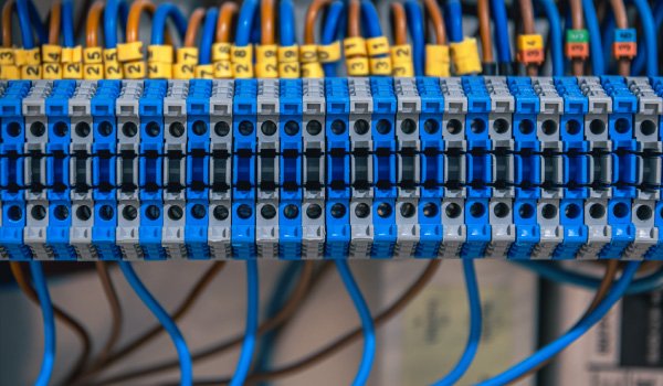 Primer plano de bornera con cables de red azules y naranjas ordenados
