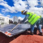 Técnico realizando mantenimiento de paneles solares en una cubierta