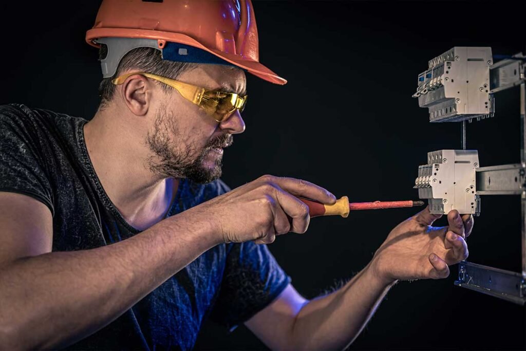 Técnico ajustando componentes eléctricos con destornillador aislado