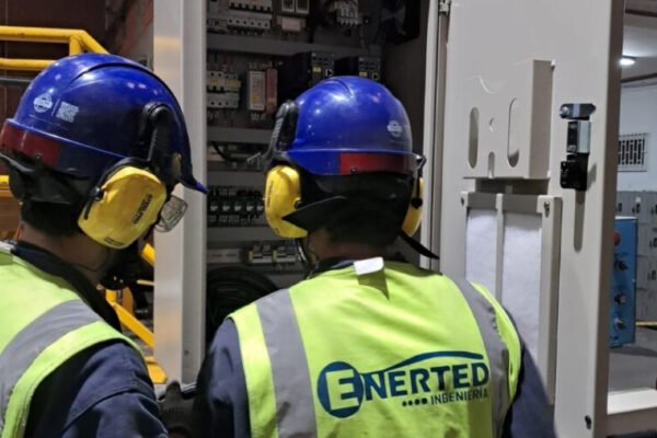 Técnicos de Enerted inspeccionando un tablero eléctrico abierto