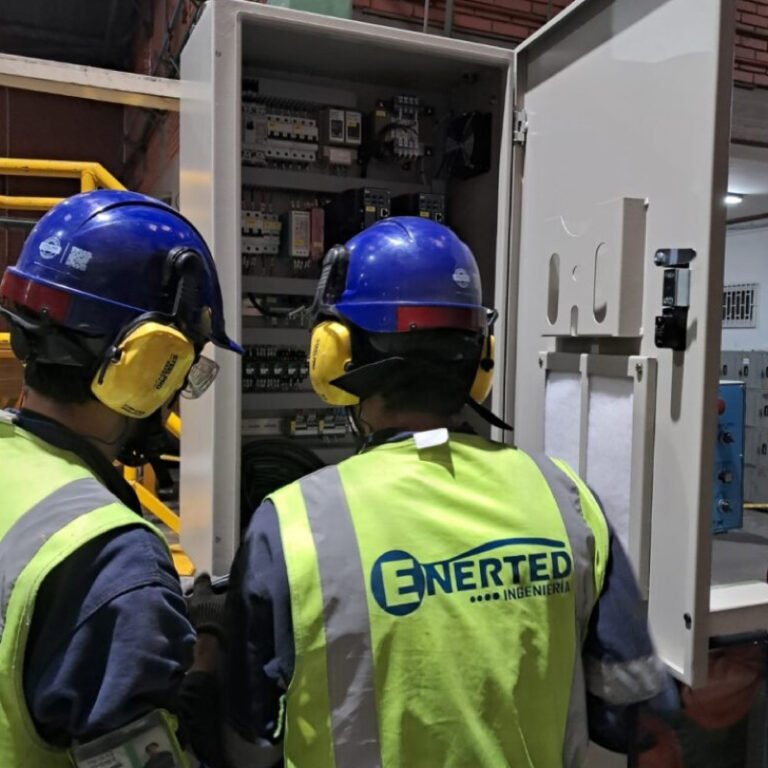 Técnicos de Enerted inspeccionando un tablero eléctrico abierto