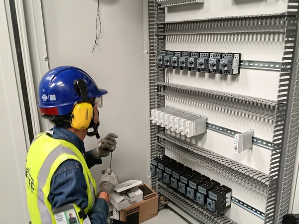 Técnico de Enerted cableando un tablero de control en planta