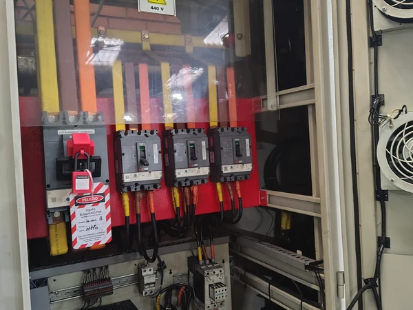 Tablero eléctrico industrial abierto con protecciones señalizadas