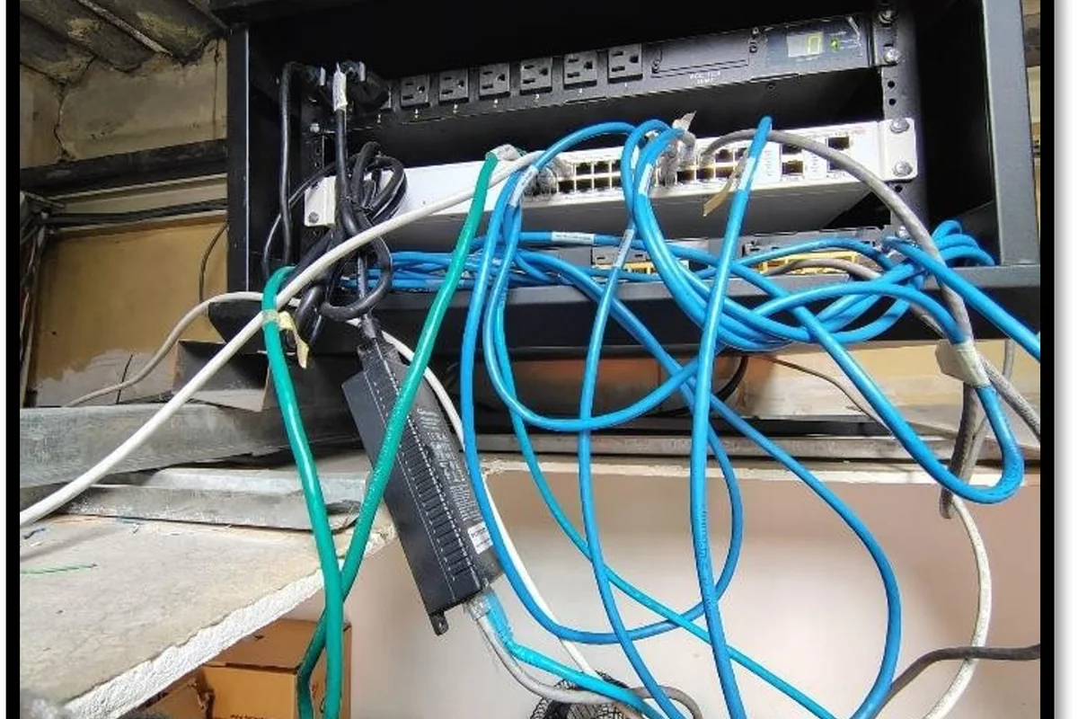 Rack de comunicaciones antes del mantenimiento, con el cableado de red sin organizar