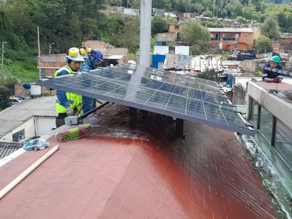 Arreglo de paneles solares montado sobre estructura en cubierta, con la cuadrilla de Enerted