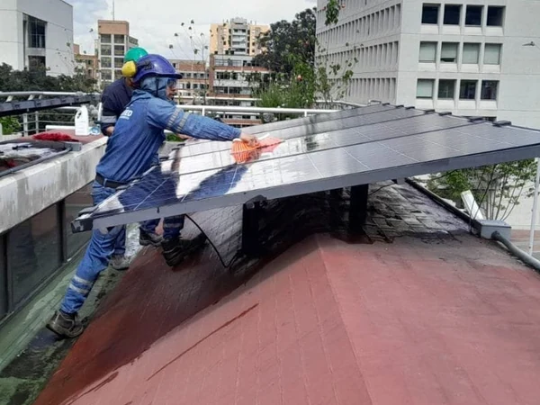 Técnico de Enerted instalando un panel solar en la cubierta de un edificio en Bogotá