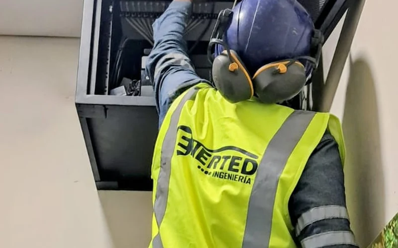 Técnico de Enerted haciendo mantenimiento dentro de un gabinete de comunicaciones